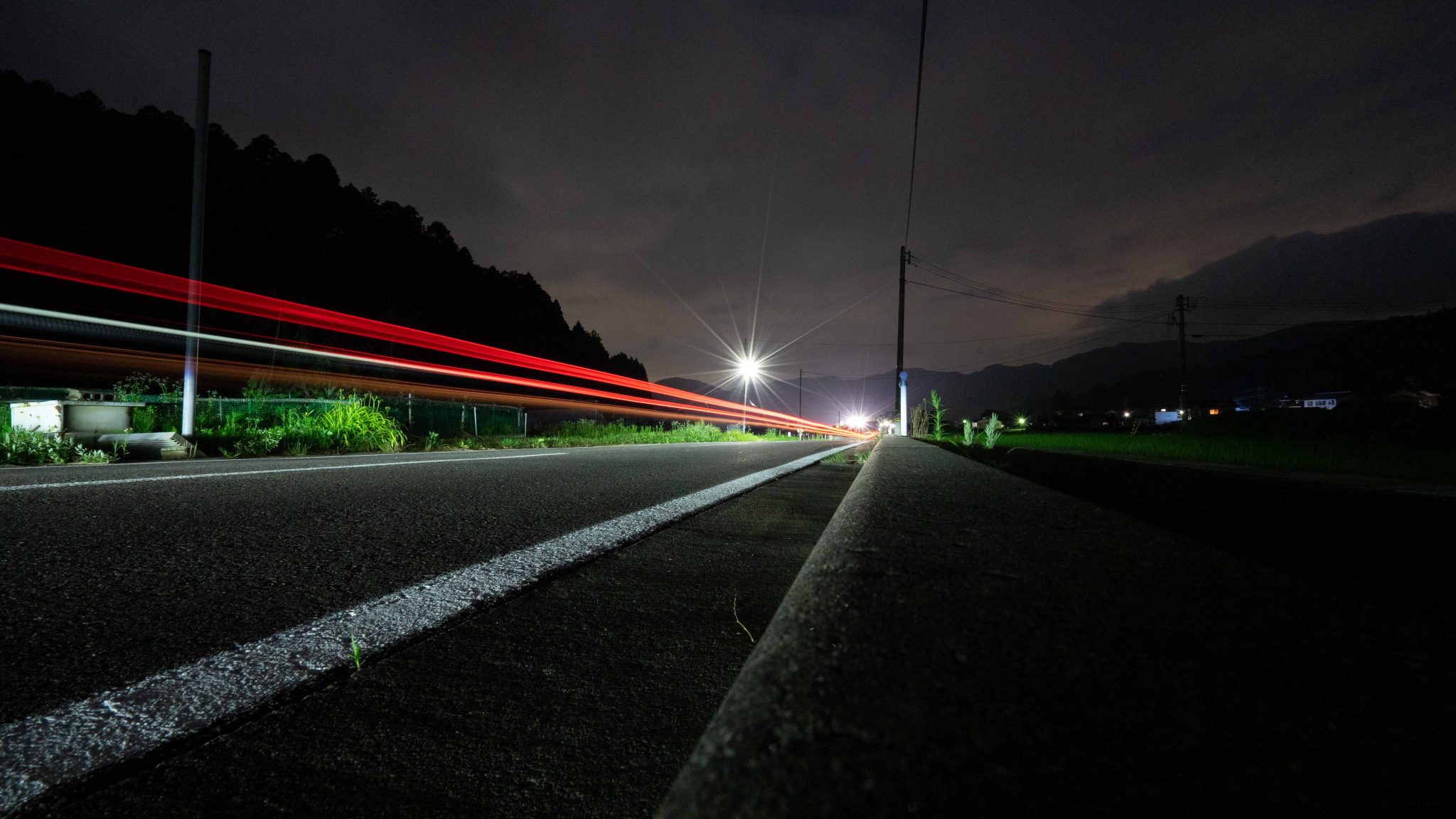 Red light trail along road at night.