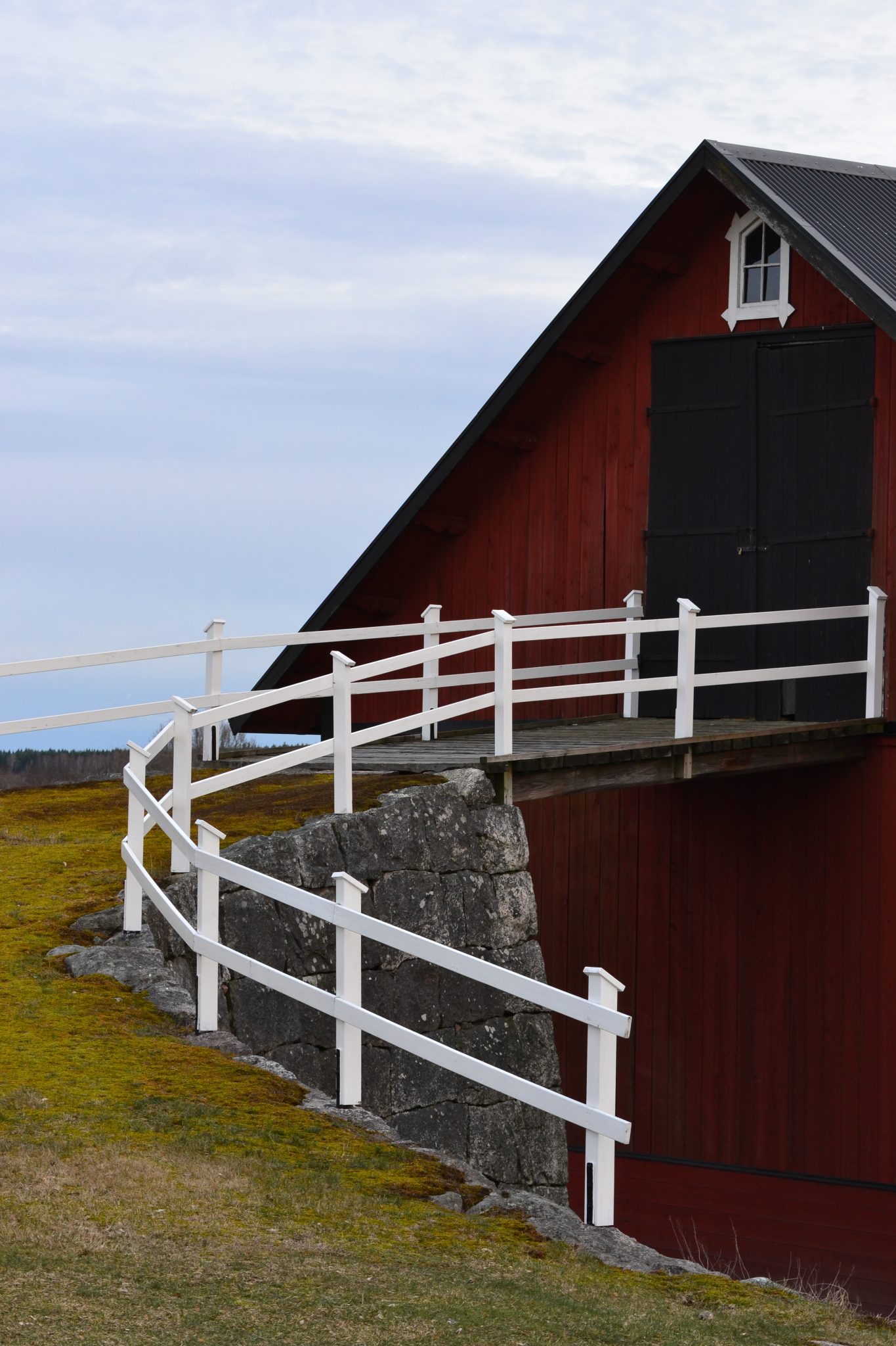 Traditional red barn with hay loft in cloudy weather