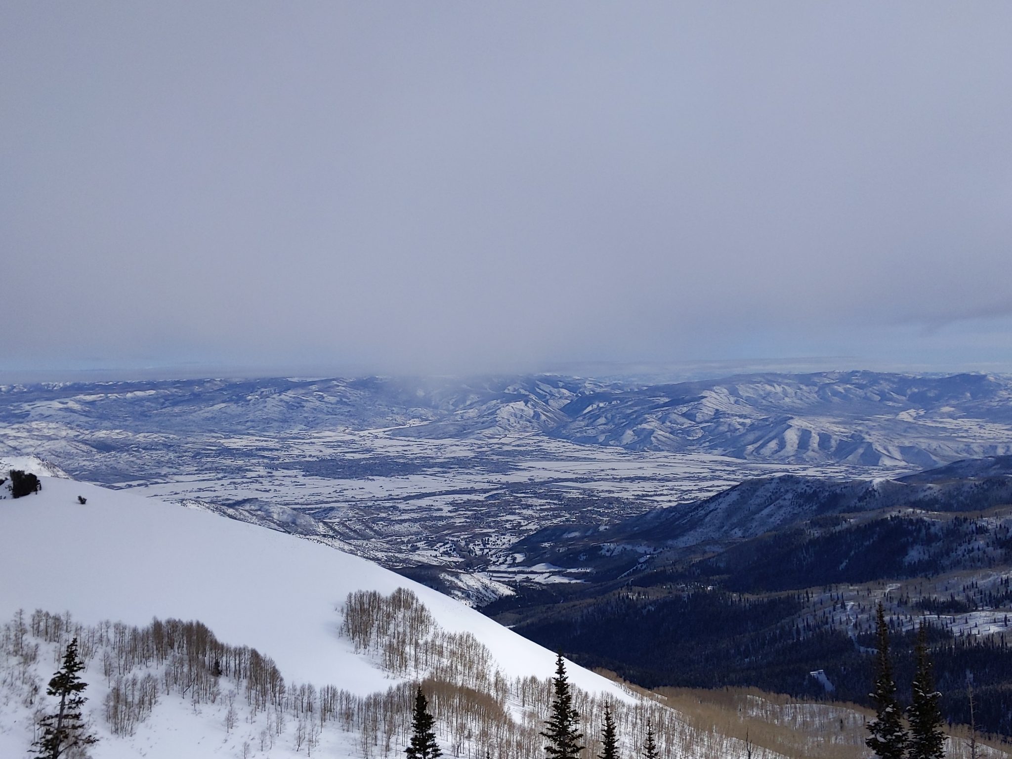 A snow-covered valley in Utah seen from above.