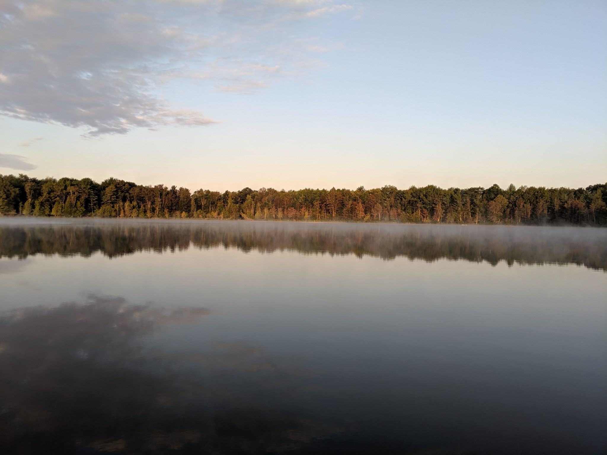 Small lake surrounded by colorful trees in the autumn