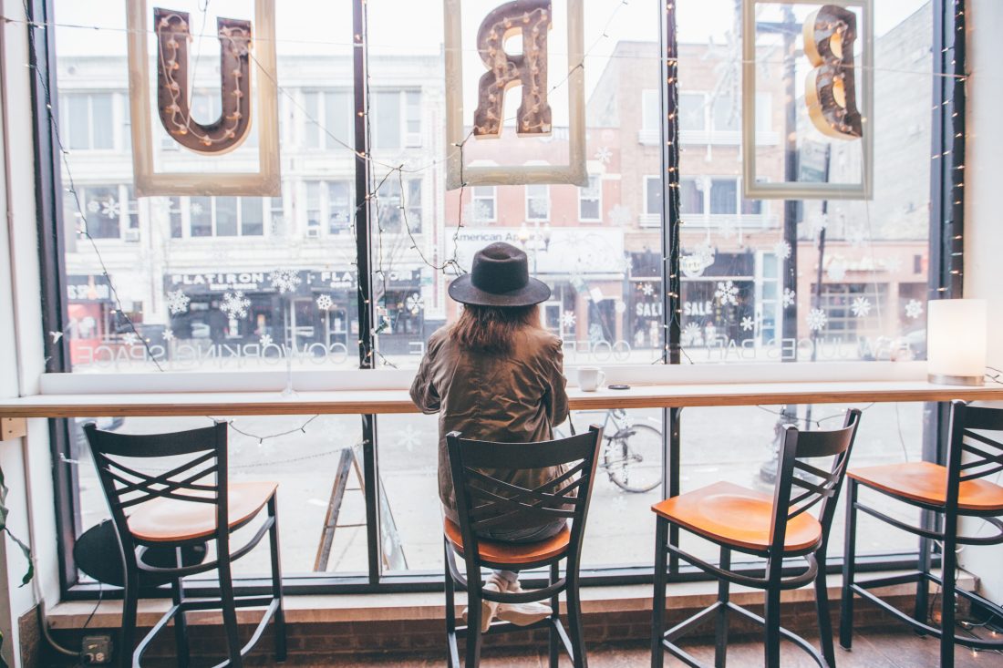 Woman Sitting at Window Coffee Shop