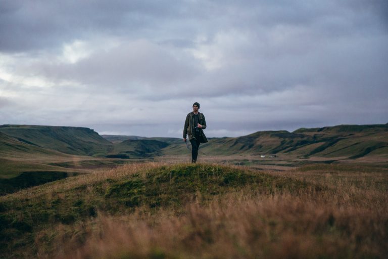 Man Hiking Under Clouds