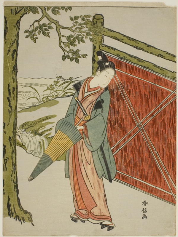 Young Man Holding Umbrella Beside a Fence
